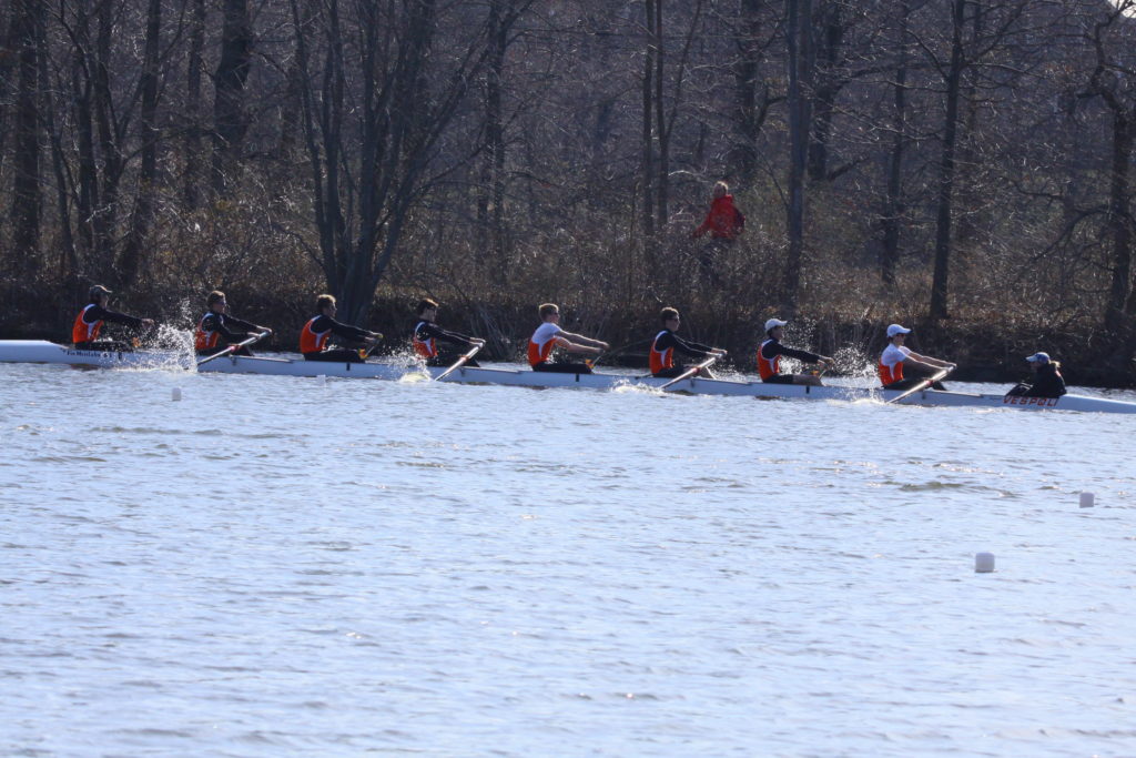 A group of people rowing a boat in the water