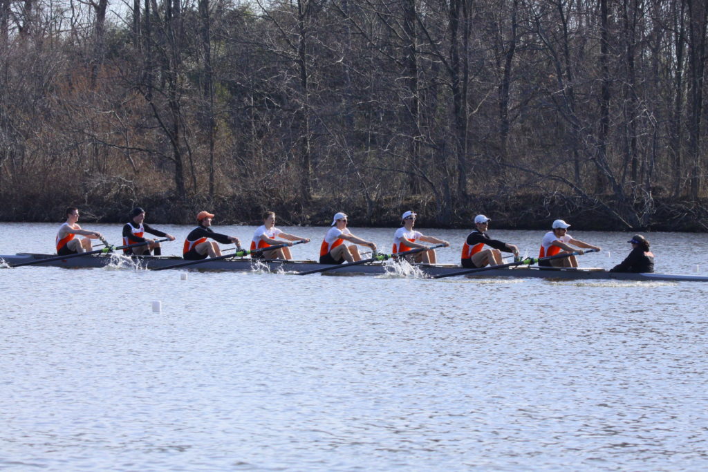 A group of people rowing a boat in a body of water