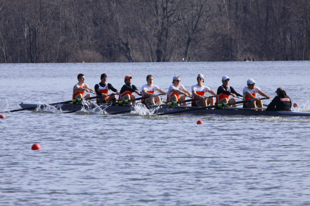 A group of people rowing a boat in the water