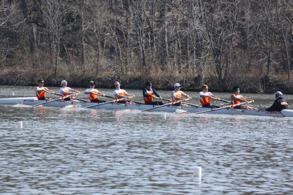 A group of people rowing a boat in the water