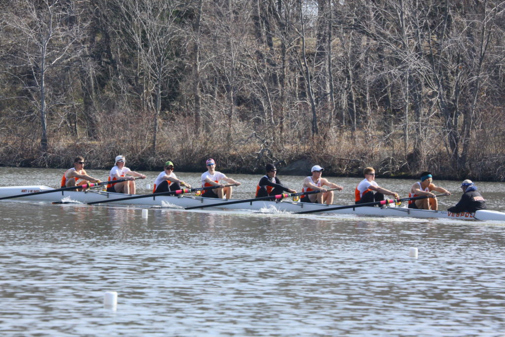 A group of people rowing a boat in the water