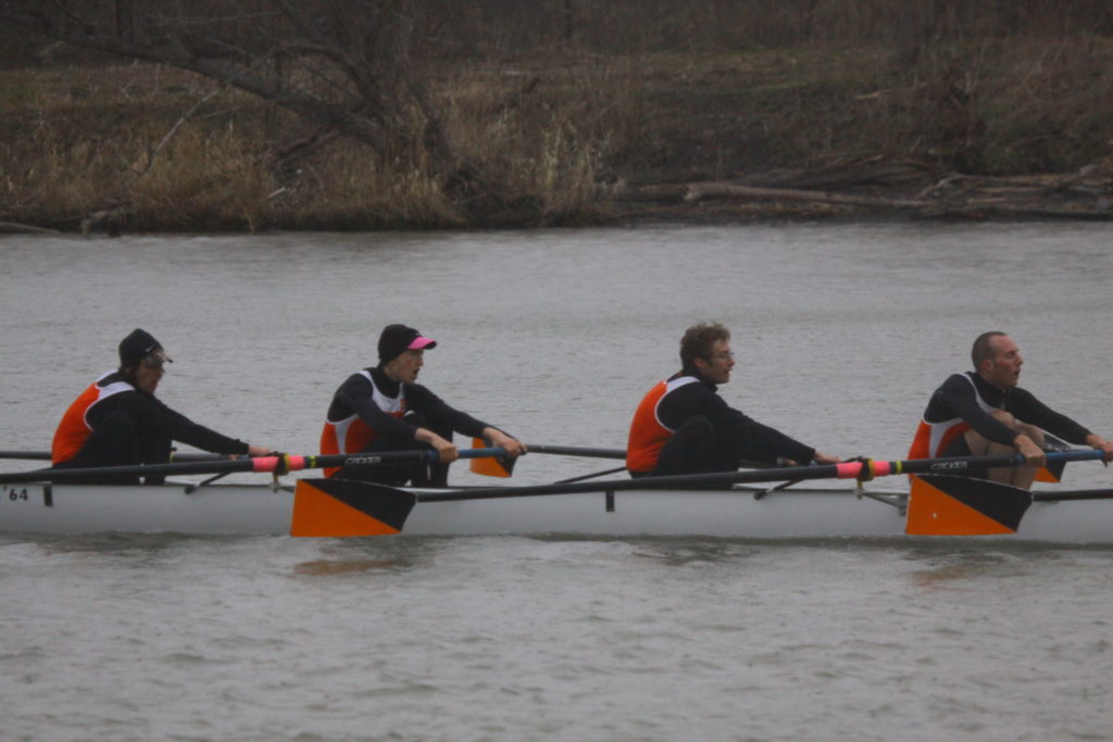 A group of people rowing a boat in the water