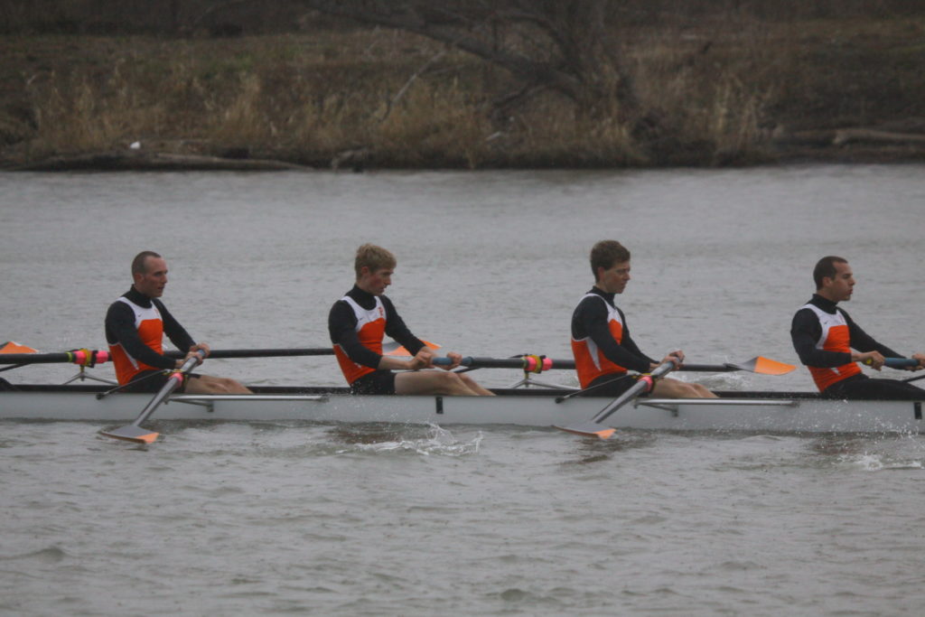 A group of people rowing a boat in a body of water