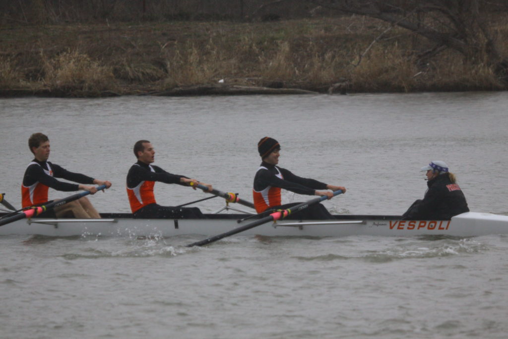 A group of people rowing a boat in a body of water