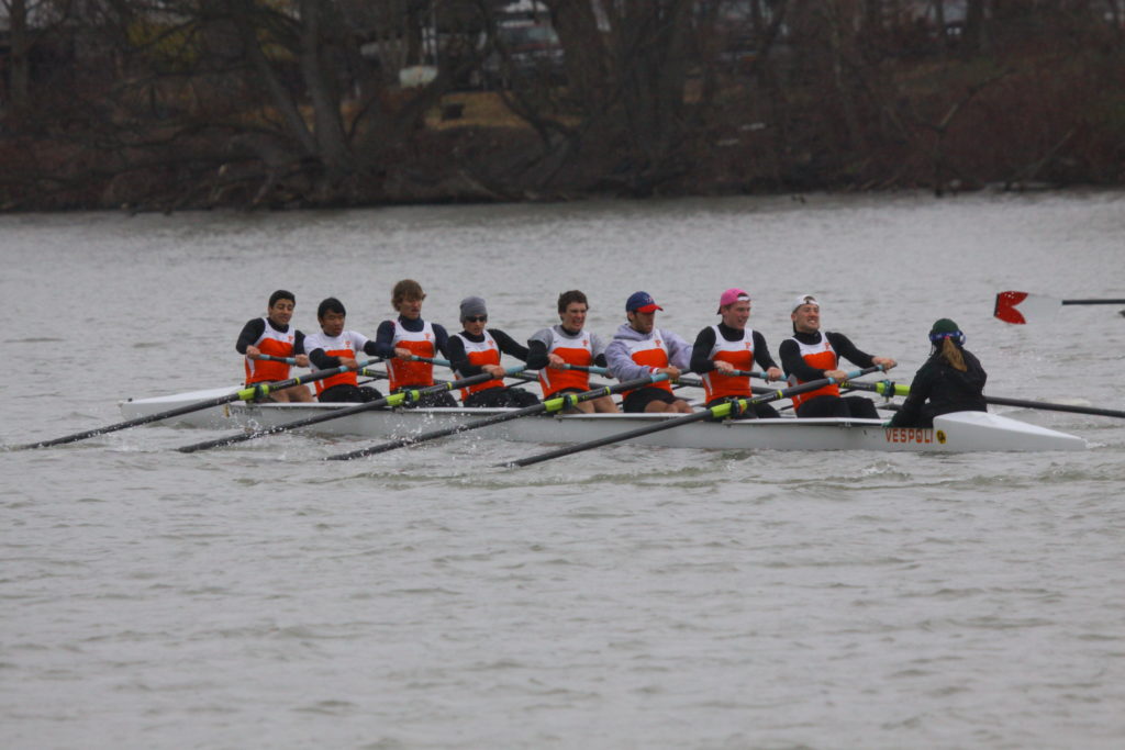 A group of people rowing a boat in the water