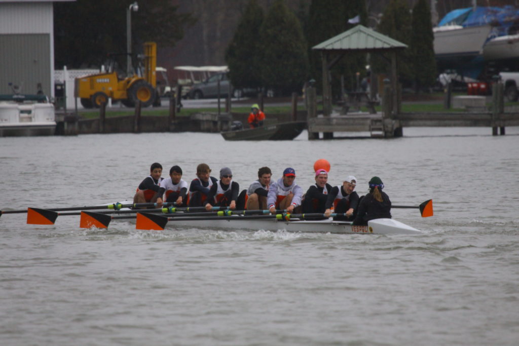 A group of people rowing a boat in the water