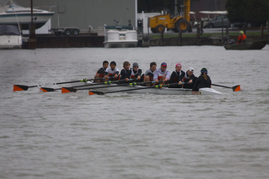 A group of people rowing a boat in the water