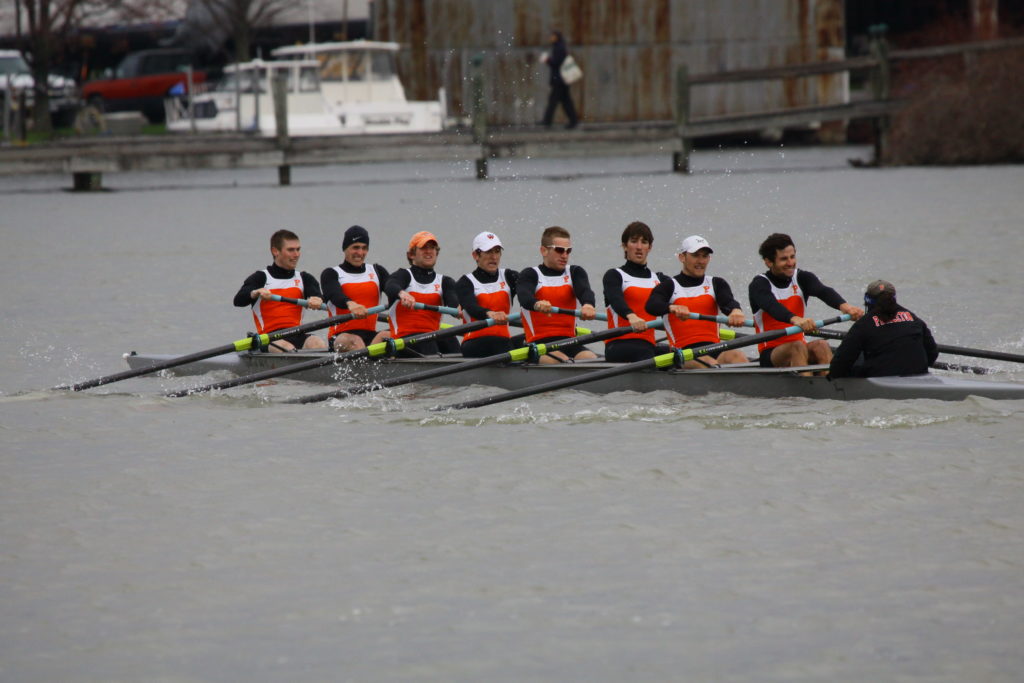 A group of people rowing a boat in the water