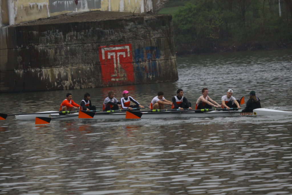 A group of people rowing a boat in the water