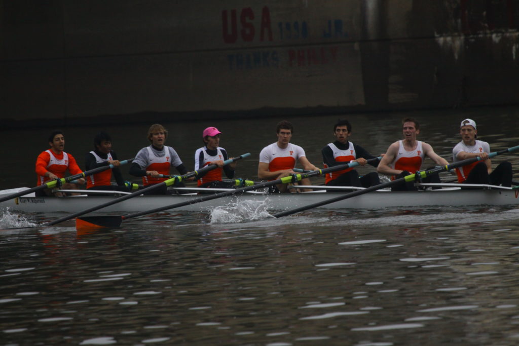 A group of people rowing a boat in the water