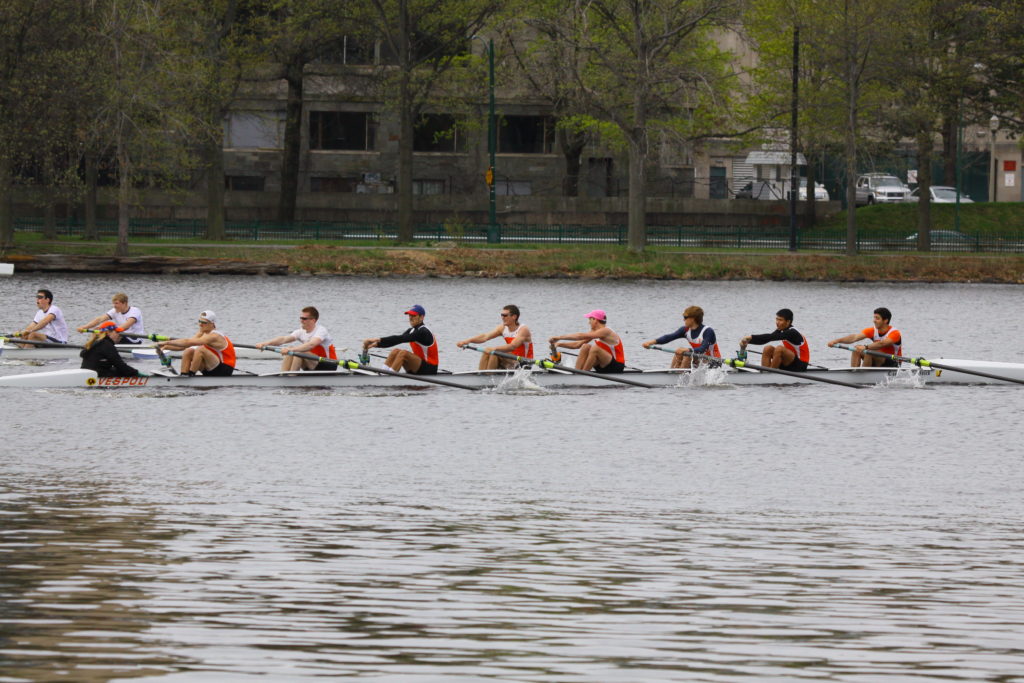 A group of people rowing a boat in the water