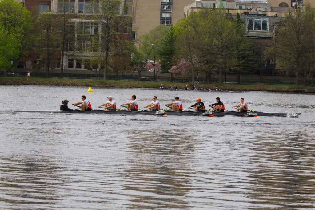 A group of people rowing a boat in a body of water