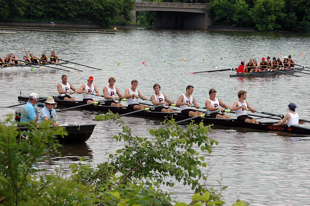 A group of people rowing a boat in a body of water