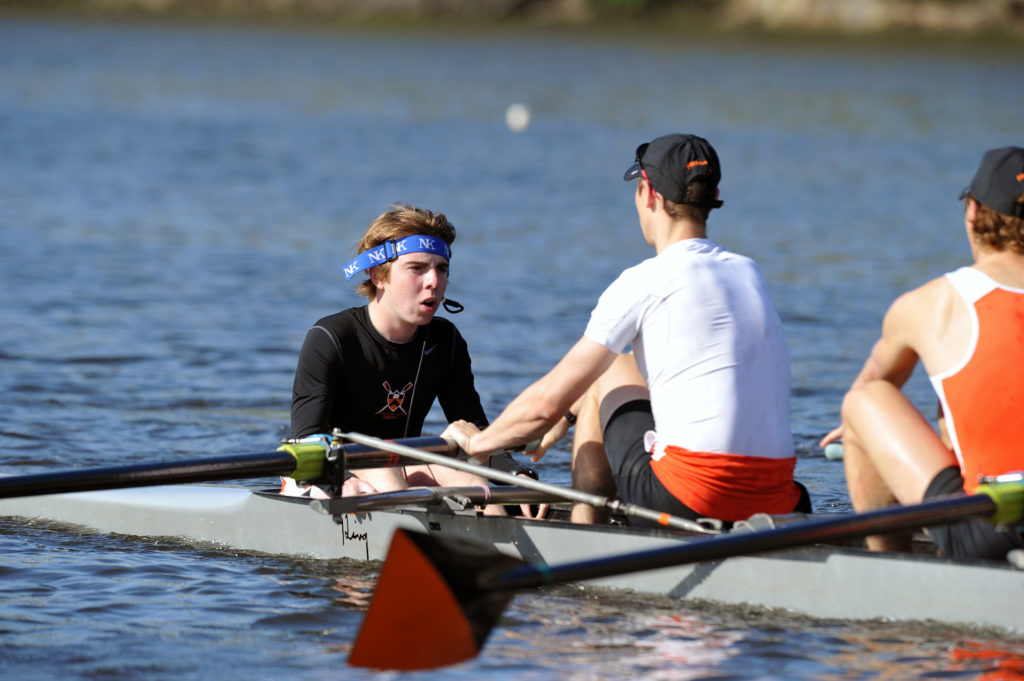 A group of people rowing a boat in the water