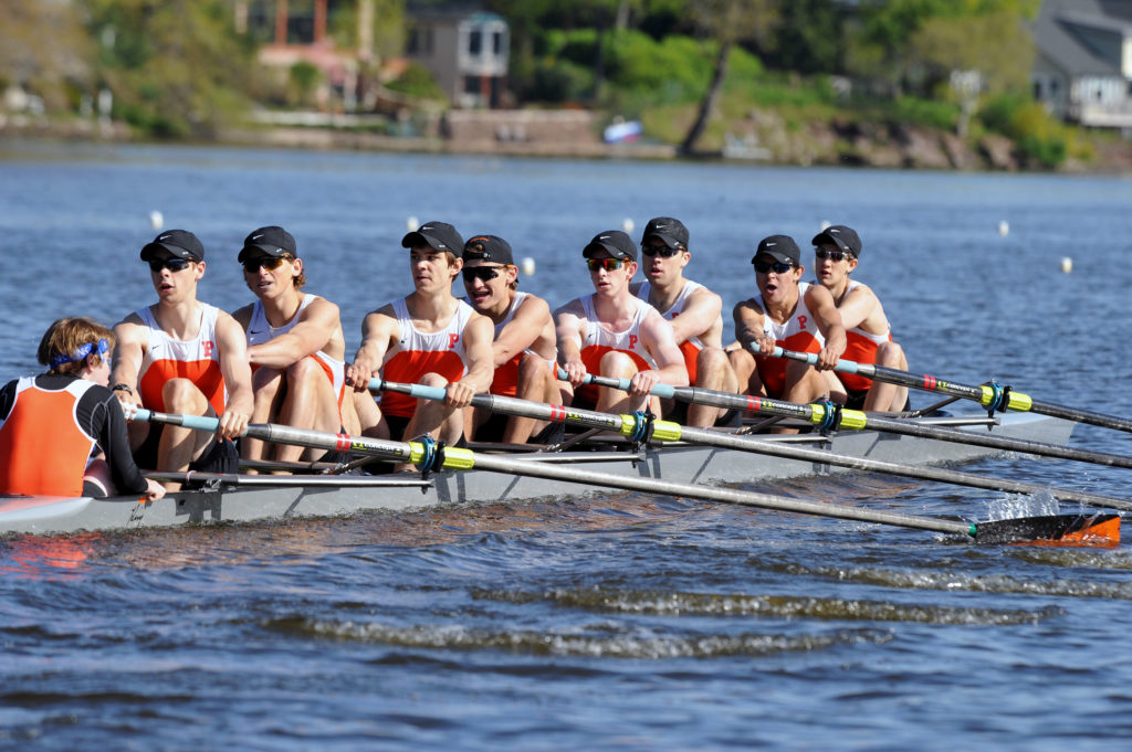 A group of people rowing a boat in the water