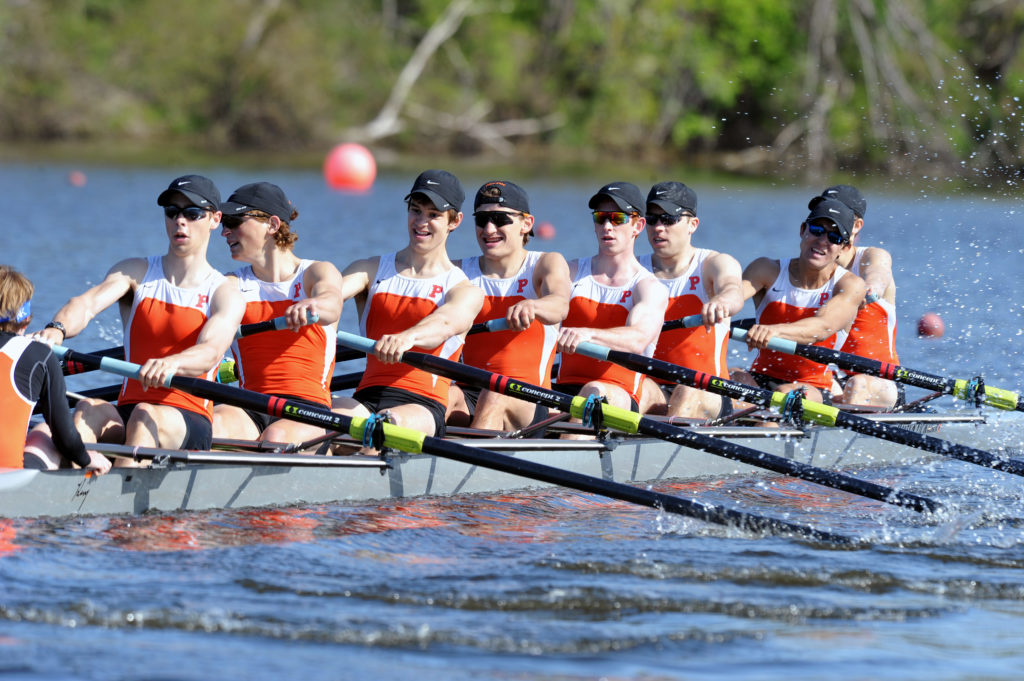 A group of people rowing a boat in the water