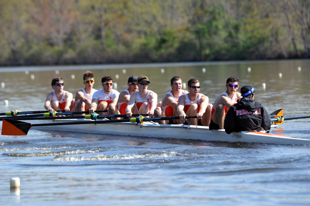 A group of people rowing a boat in the water