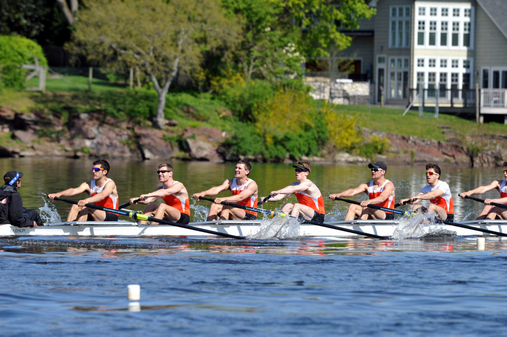 A group of people rowing a boat in the water