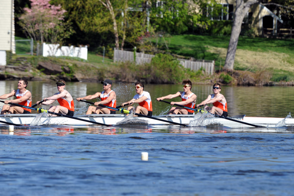 A group of people rowing a boat in the water