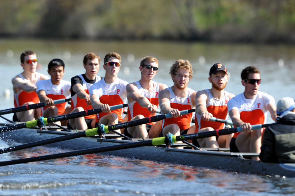 A group of people rowing a boat in the water