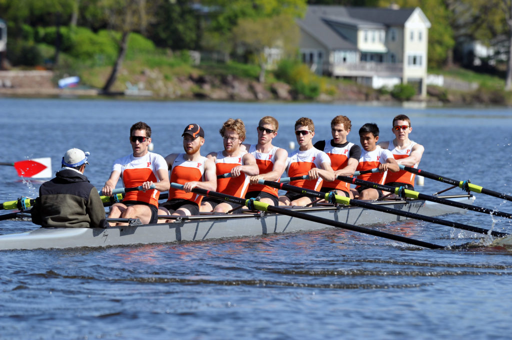 A group of people rowing a boat in the water