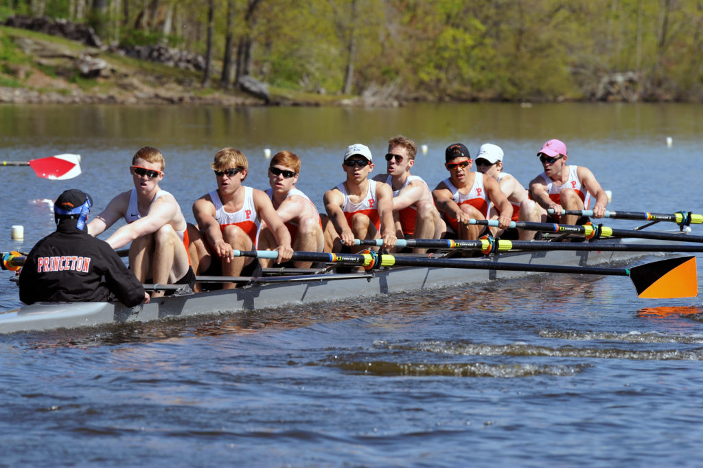 A group of people rowing a boat in the water