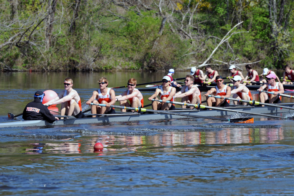 A group of people rowing a boat in the water