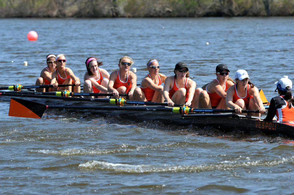 A group of people rowing a boat in a body of water