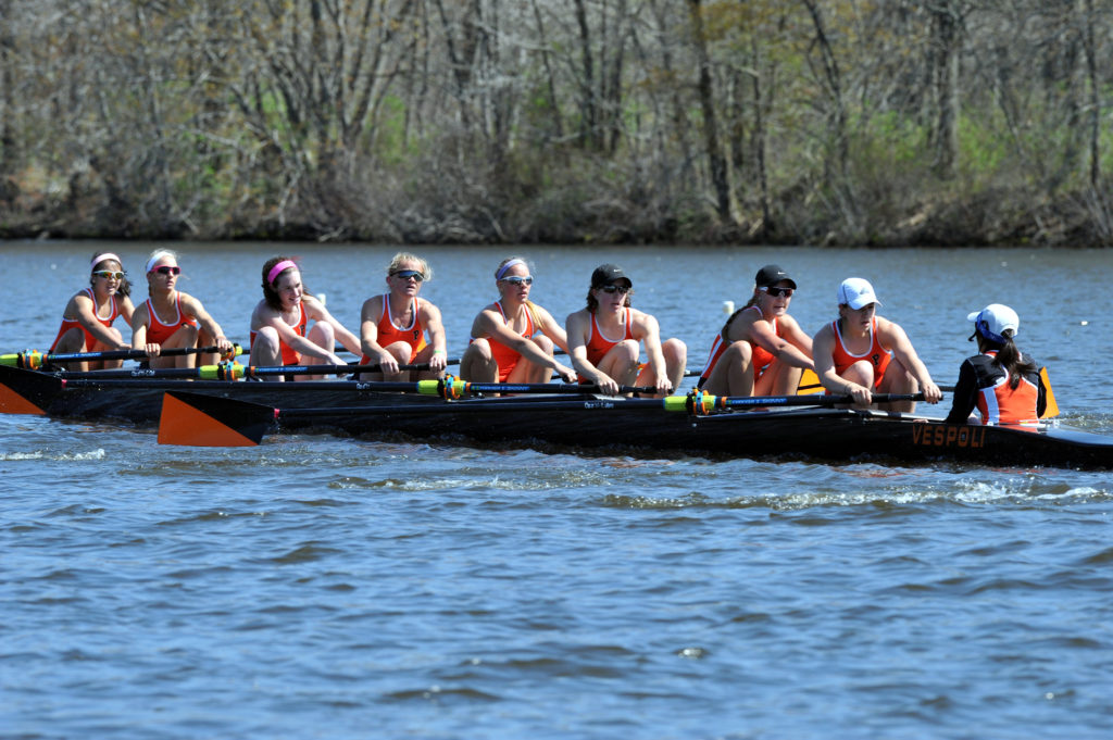 A group of people rowing a boat in the water