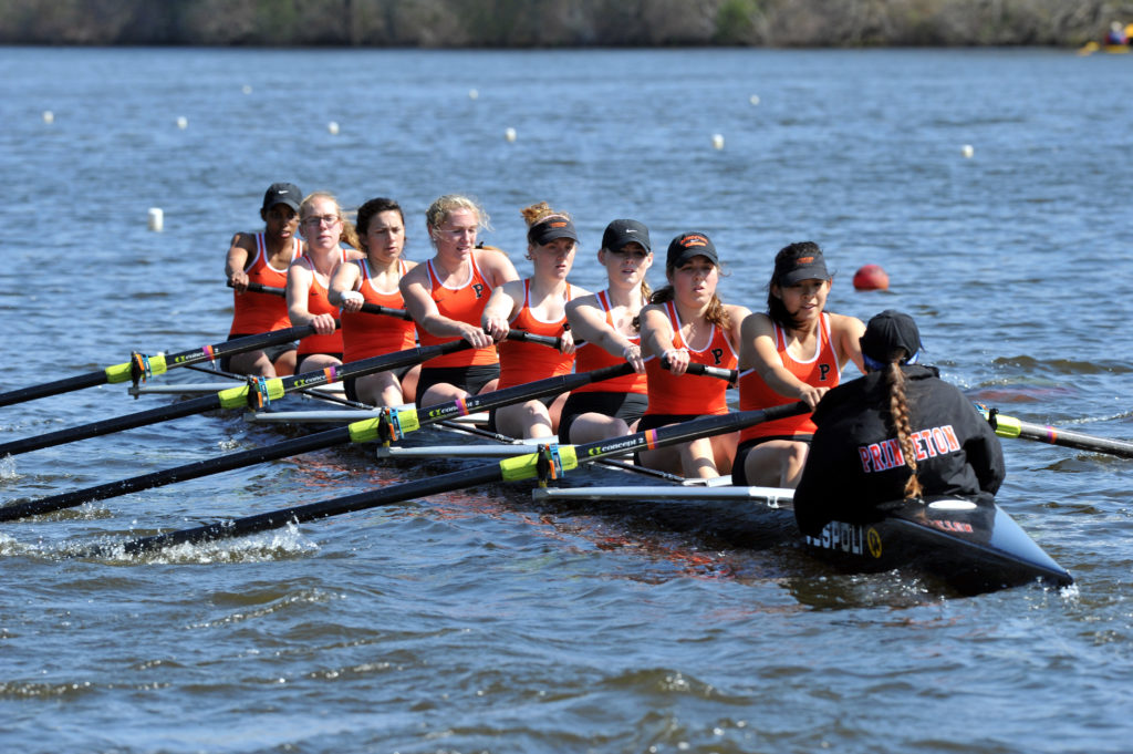 A group of people rowing a boat in a body of water