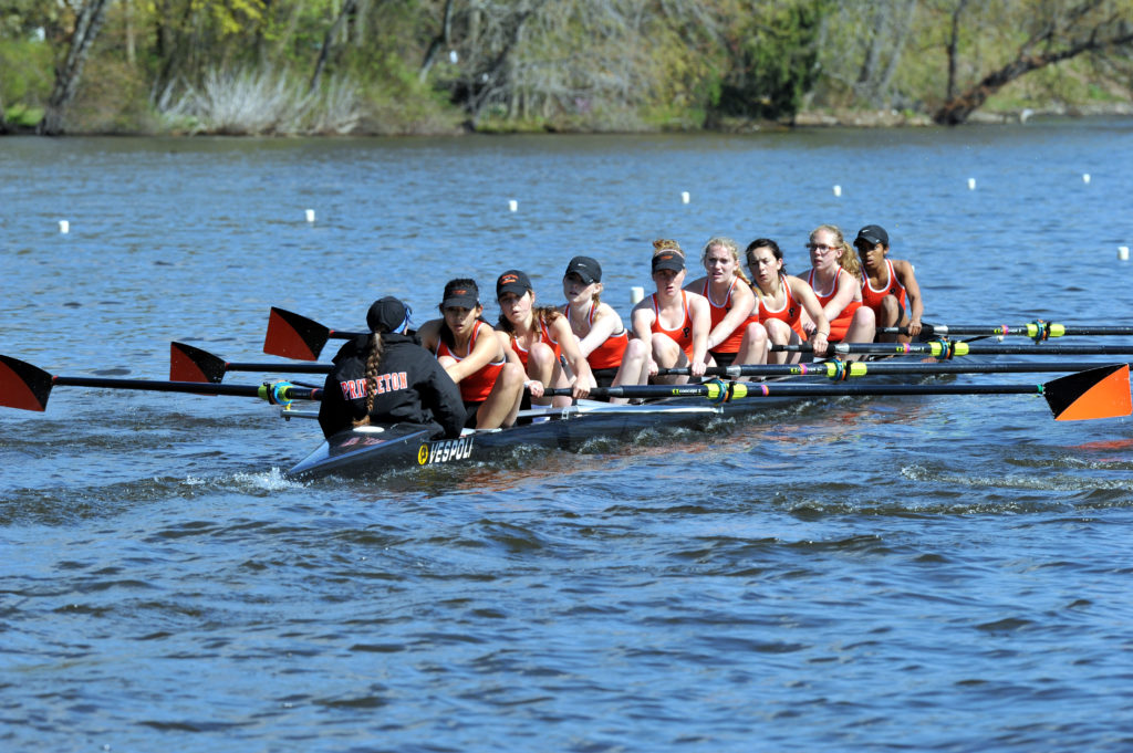 A group of people rowing a boat in a body of water