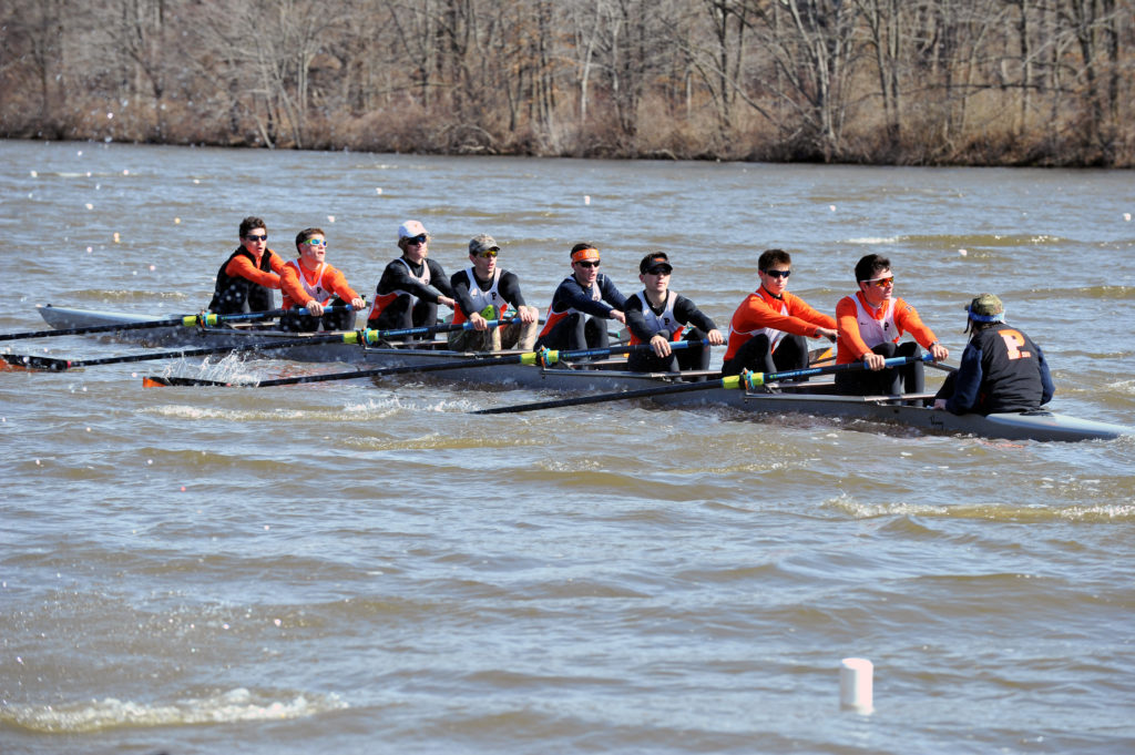 A group of people rowing a boat in the water