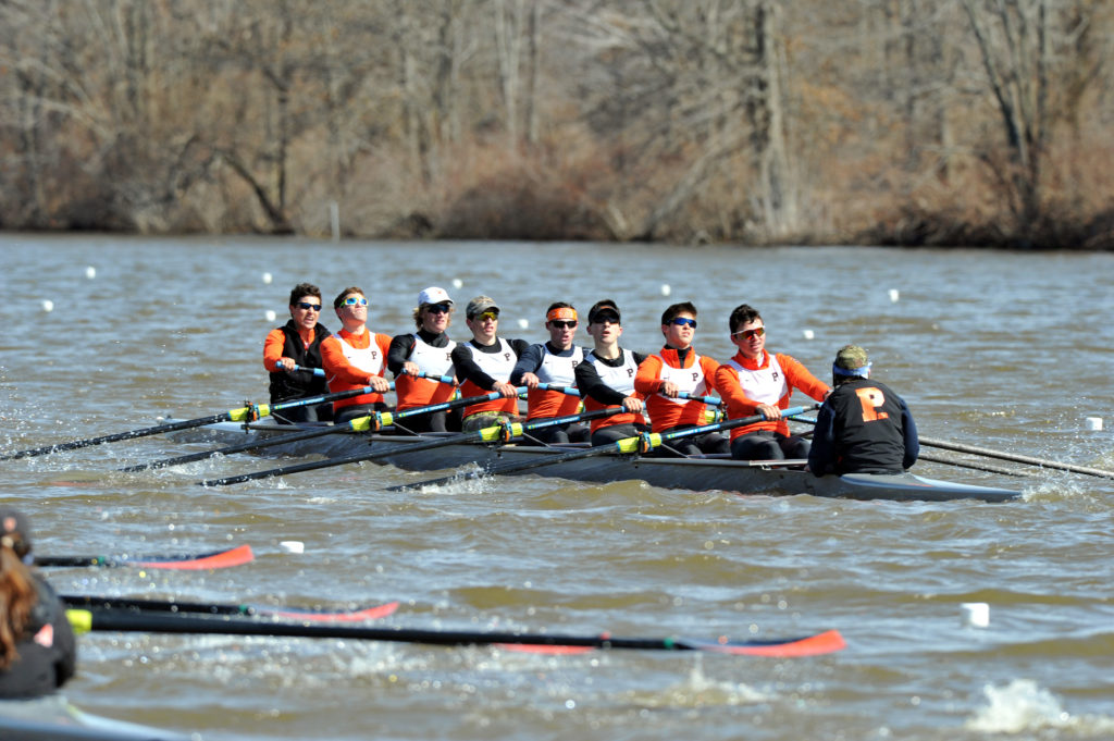 A group of people rowing a boat in a body of water