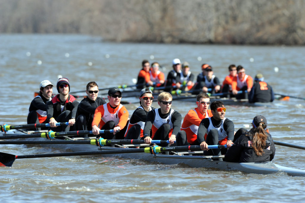 A group of people rowing a boat in the water