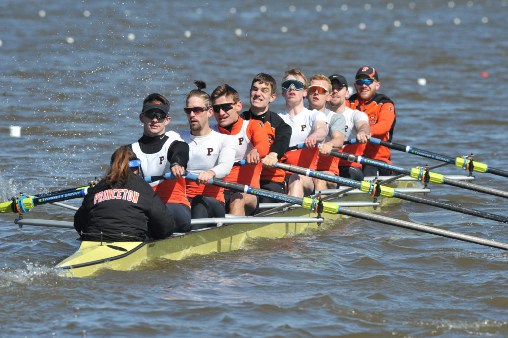 A group of people rowing a boat in a body of water