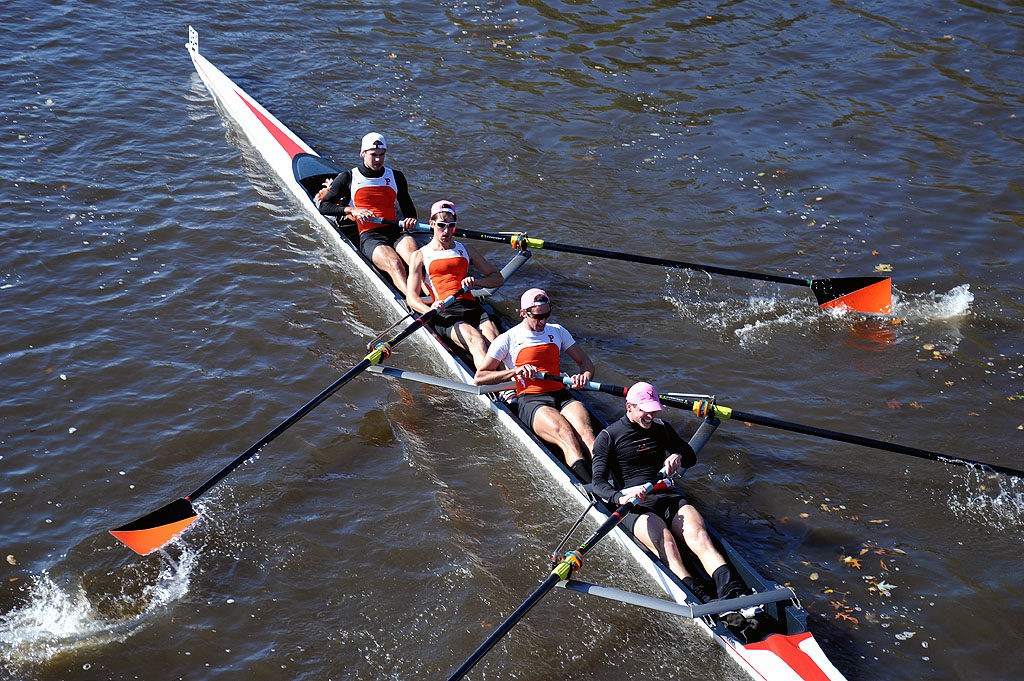 A group of people rowing a boat in a body of water