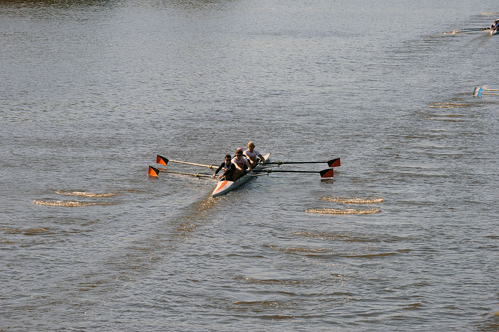 A group of people rowing a boat in a body of water