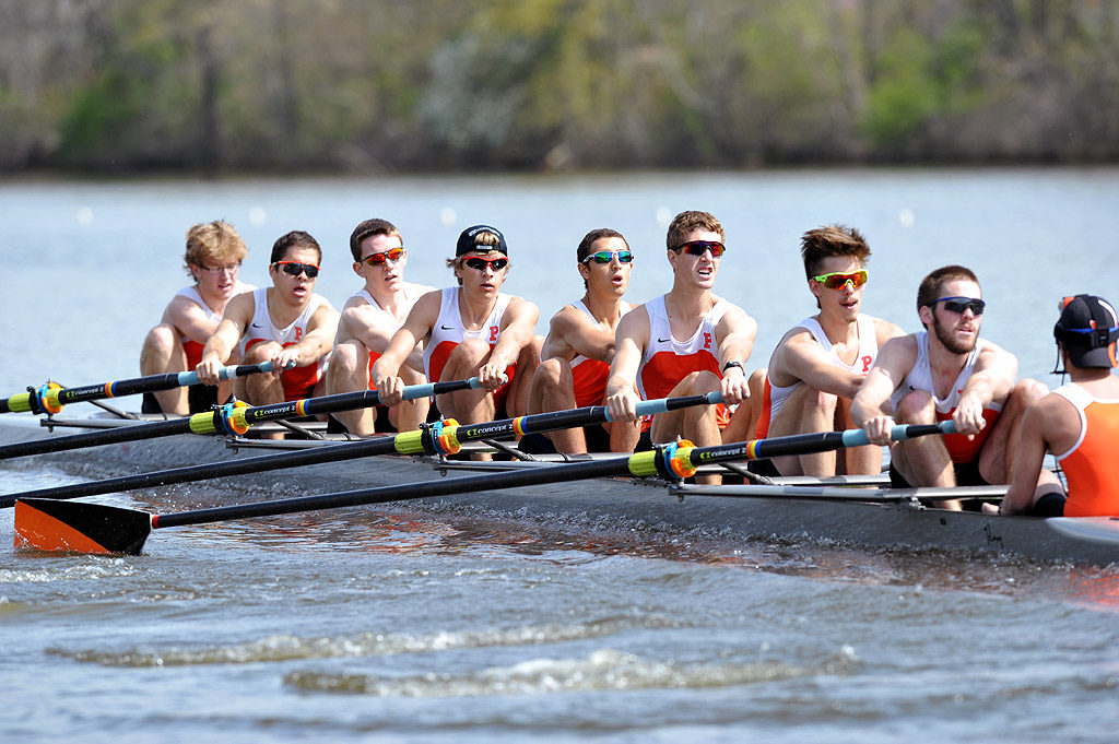 A group of people rowing a boat in the water