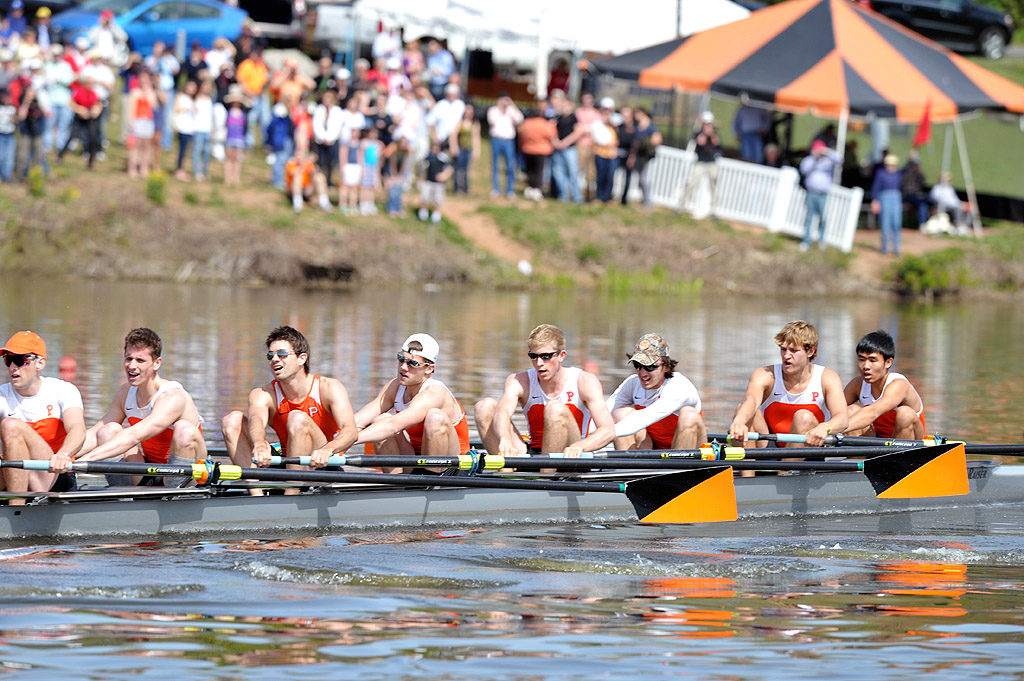 A group of people rowing a boat in the water