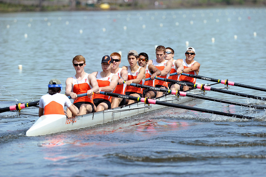 A group of people rowing a boat in a body of water