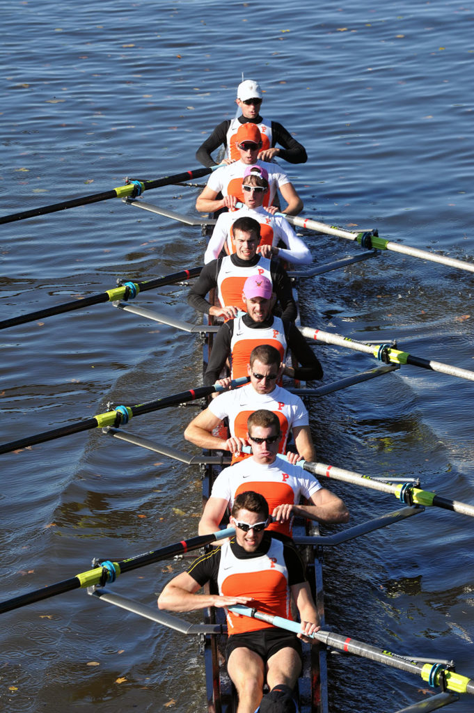 A group of people rowing a boat in the water