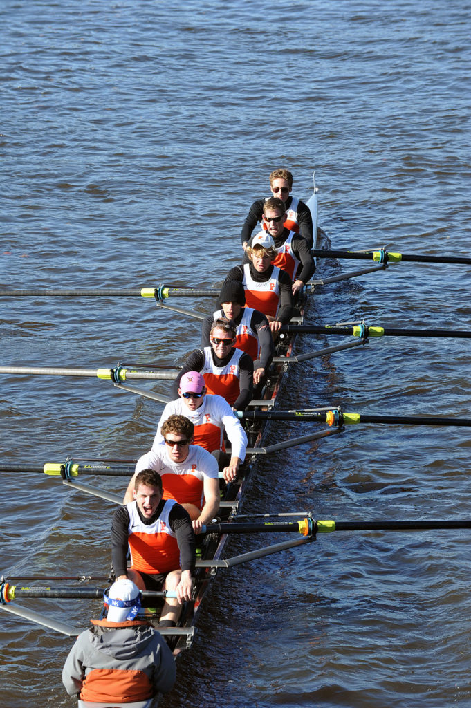 A group of people rowing a boat in the water