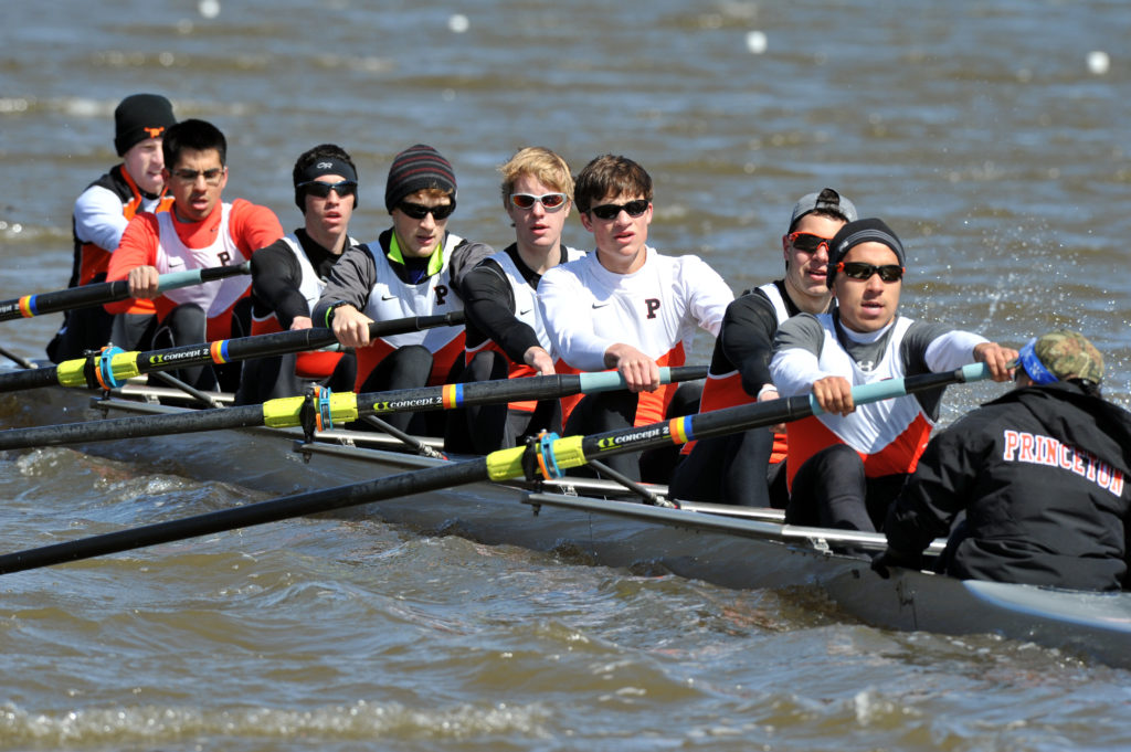 A group of people rowing a boat in the water