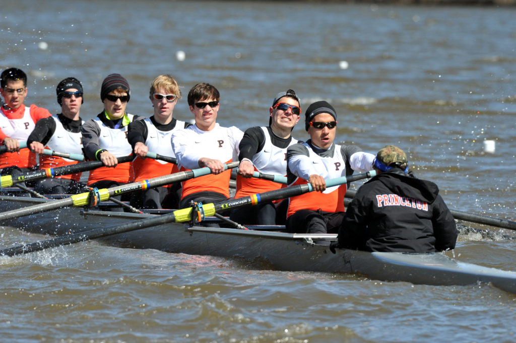 A group of people rowing a boat in a body of water