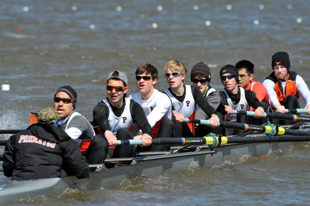 A group of people rowing a boat in the water