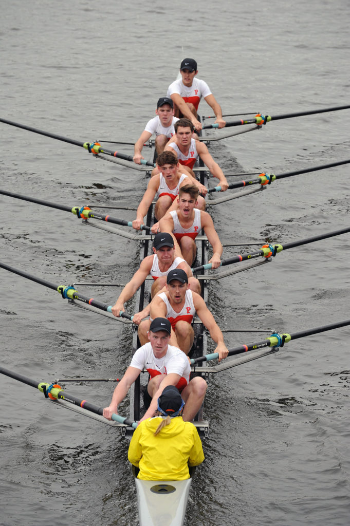 A man riding on the back of a boat in the water