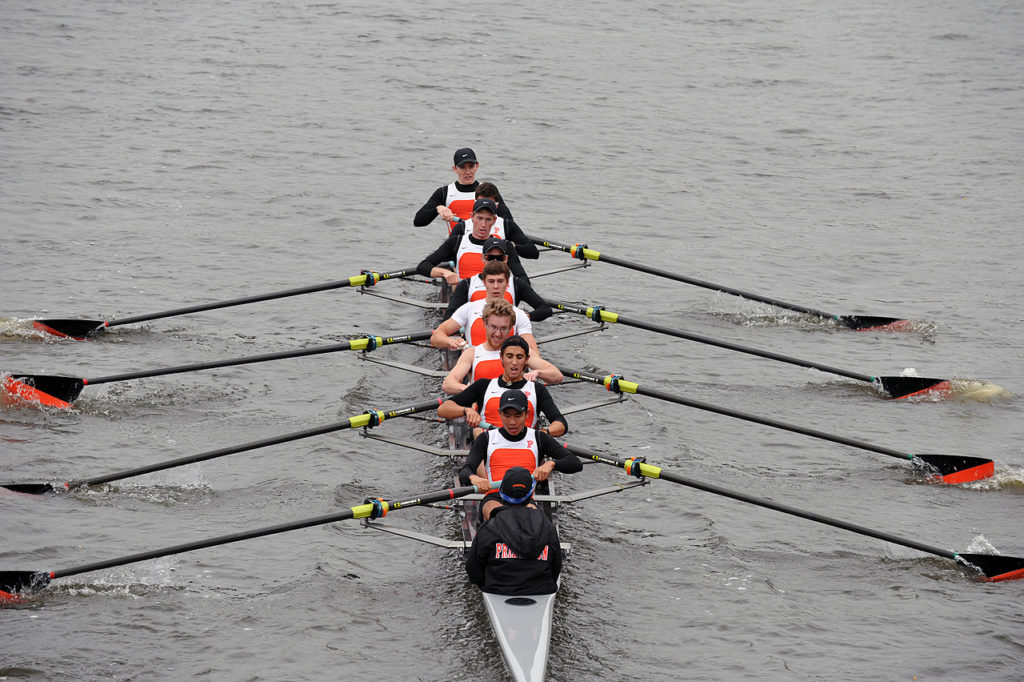 A group of people rowing a boat in the water