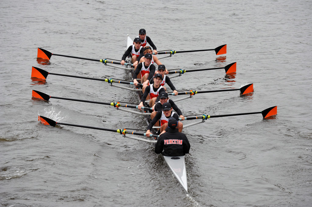 A group of people rowing a boat in the water