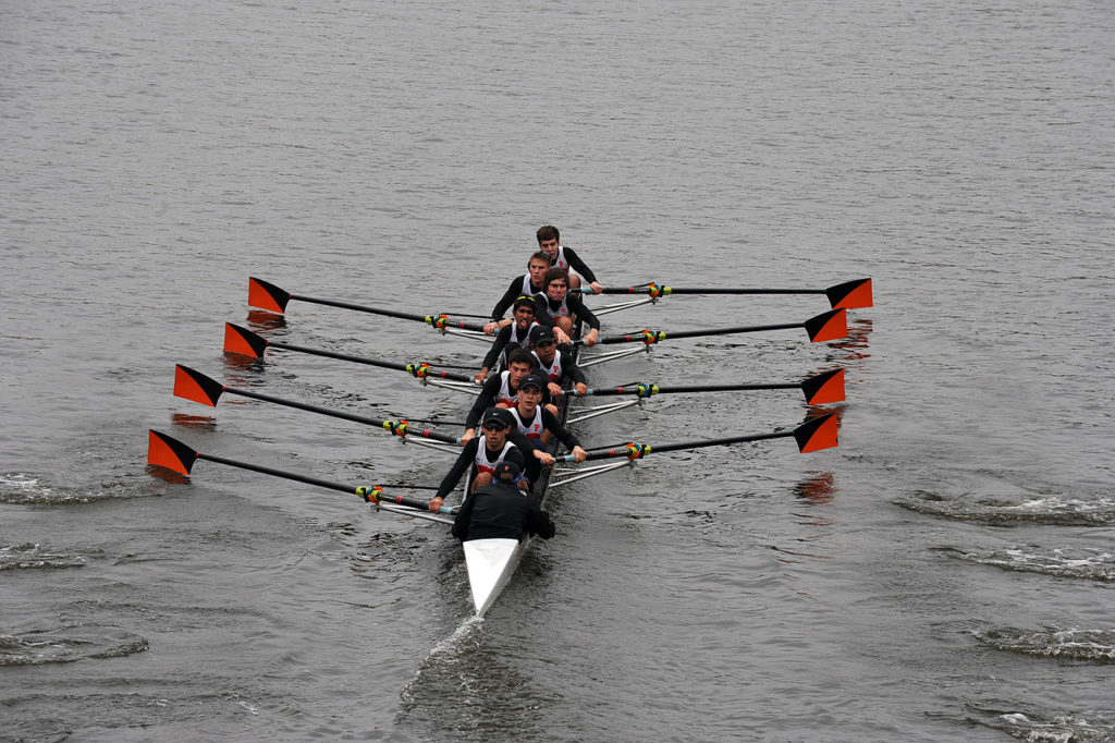 A group of people rowing a boat in the water