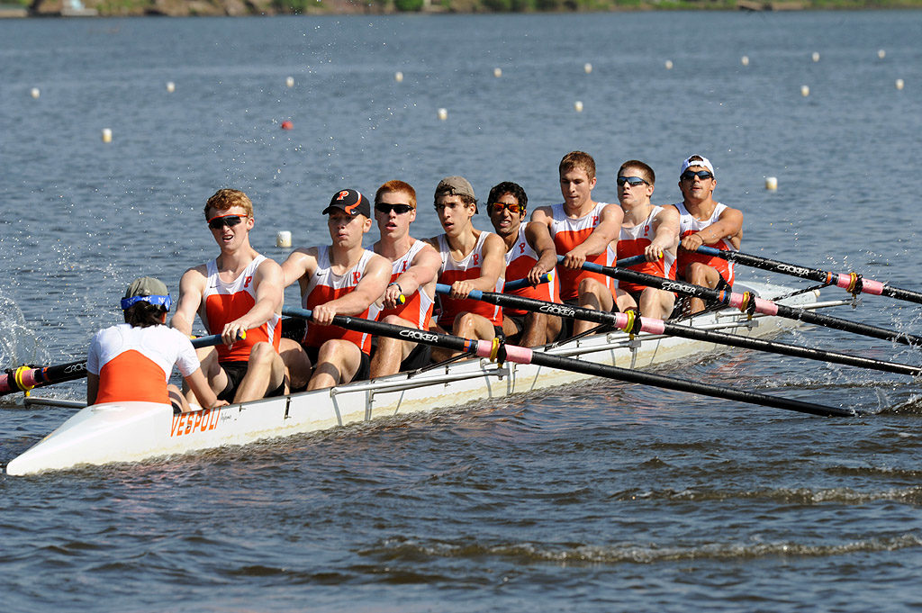 A group of people rowing a boat in the water